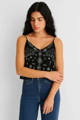 Musculosa negra de breteles finos con escote en V y bordado blanco con motivos geométricos.