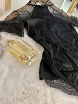 Body negro de terciopelo acanalado con detalles de microtul y encaje, cuello alto y espalda descubierta.