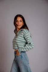 Sweater de punto color beige con rayas horizontales blancas, cuello polo con cierre de cremallera y mangas largas.