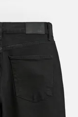Pantalón de jean azul oscuro, corte slim fit, tiro medio, cinco bolsillos, tejido elástico y efecto lavado.