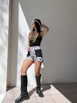 Short de denim elastizado con estampado animal print de vaca en blanco y negro, con bolsillos frontales de parche en color negro. Tiro alto y corte ajustado.