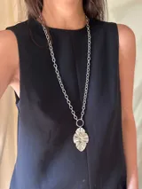 Collar plateado de doble cadena con dije colgante con forma de hoja.