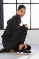 Campera deportiva negra con capucha y cierre frontal.