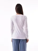 Remera blanca de manga larga con cuello redondo y estampado abstracto en tonos pastel.