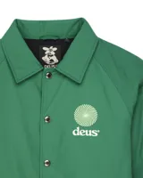 Campera tipo coach color verde con logo de la marca Deus en el pecho.