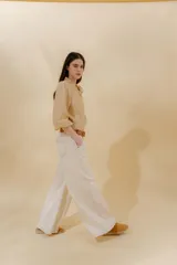 Pantalón de jean azul con corte sastrero de tiro medio bajo confeccionado en 100% algodón. Presenta cortes en los costados, dos bolsillos delanteros y dos traseros.