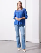 Blusa verde agua de gasa marca Figueroa & Flower, con cuello redondo y aplique de crochet. Tiene mangas 3/4 amplias con puño y botón, y forro interno a tono.
