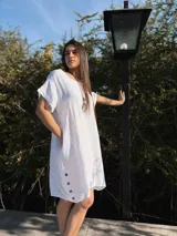 Vestido amarillo de lino con cuello redondo y mangas cortas con dobladillo. Tiene botones de madera en los laterales.