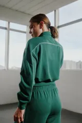 Conjunto deportivo azul marino con detalles de ribete blanco. Incluye una campera corta con cierre y un pantalón de corte recto.