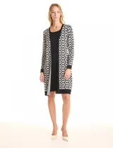 Vestido de tejido de punto marca Nina Leonard, con diseño Twofold que simula un conjunto de vestido negro liso y cárdigan largo con estampado geométrico blanco y negro. Presenta escote redondo y manga larga de corte recto.