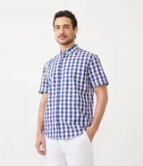 Camisa de manga corta con estampado de cuadros azules y blancos. Fabricada con una mezcla de algodón y poliéster, la pieza es transpirable y no se arruga fácilmente.