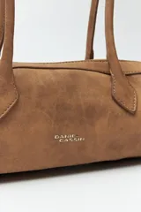 Cartera baguette color marrón claro, confeccionada en símil cuero con formato cilíndrico y doble asa corta.