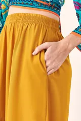 Pantalón palazzo color mostaza, de tiro alto y corte holgado.