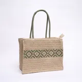 Bolso tipo tote de yute color beige, con diseño geométrico bordado en verde y doble asa de mano verde.