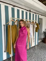 Vestido midi fucsia de lino, con cuello halter y corte recto.