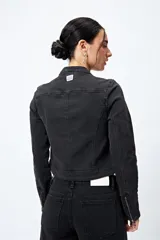 Campera entallada de denim con estampado animal print de cebra en tonos beige y negro. Tiene cuello mao con broches metálicos, cierre frontal con cremallera, bolsillos con cierre en el pecho y mangas largas con puños con cierre.