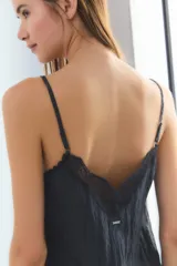 Conjunto de pijama negro con ribete de encaje en el escote del top y en el ruedo del pantalón.