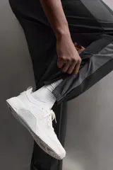 Pantalón relaxed fit confeccionado en tejido técnico ligero y elástico en todas direcciones. Cintura elástica ajustable con cordón interior, bolsillos delanteros y bajo acabado en elástico y ajustable con cremallera.