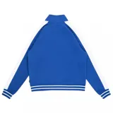 Campera deportiva azul con cierre frontal, cuello alto y mangas largas con franjas blancas. Tiene bolsillos laterales con cierre y logo de Vans bordado en el pecho.