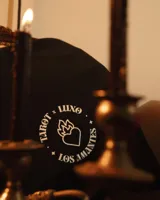 Remera negra de manga corta con cuello redondo y calce oversize. Presenta una estampa en sublimación inspirada en el tarot, con la carta de 'Los Amantes' en colores vibrantes como amarillo, rosa, violeta y verde.