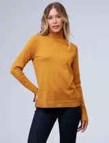 Polera de punto fino marca Nienty, color mostaza, con cuello alto, manga larga y detalle de tajo en los puños.