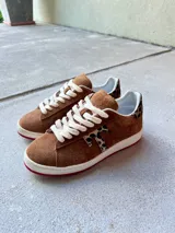 Zapatillas de carnaza pulida en color canela, con detalles en estampado animal print y cordones blancos.