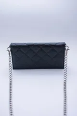 Cartera de cuero color marrón claro, con diseño capitoneado y cadena metálica plateada removible. Tiene ranuras interiores para tarjetas y documentos, y forro textil rojo.