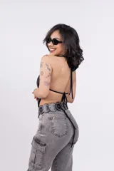 Top negro con escote drapeado tipo halter y espalda descubierta.