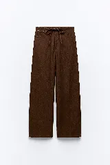 Pantalón denim fino color marrón, de corte amplio y tiro alto, con elástico en la parte trasera de la cintura y lazo ajustable.