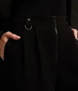 Short negro de corte sastre con cintura alta, trabillas, pliegues, hebillas metálicas y cierre frontal con cremallera.