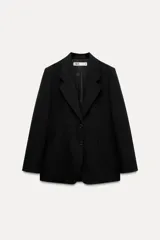 Blazer recta negra de Zara Woman Collection, con cuello solapa, manga larga con abertura y botones, bolsillos de plastrón en delantero, forro interior a tono y cierre frontal con botones.