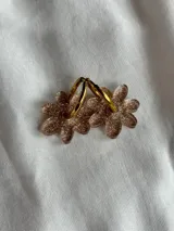 Aros colgantes plateados con dije de flor acrílica color dorado.