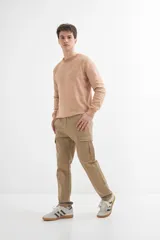 Sweater de punto color naranja claro jaspeado, con cuello redondo y mangas largas.