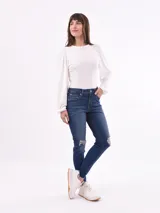 Pantalón de jean skinny azul con roturas en las rodillas y ruedo desflecado.