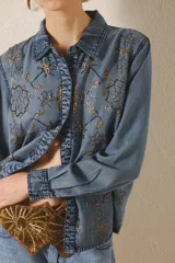 Camisa de tencel celeste con bordado de lentejuelas doradas, calce recto, manga larga y cuello camisero.