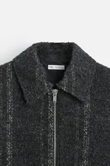 Sobrecamisa regular fit confeccionada en tejido con algodón, color gris oscuro con finas rayas verticales en blanco. Cuello solapa, manga larga con puño abotonado, bolsillos laterales y cierre frontal con cremallera.