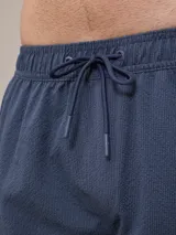 Short de baño verde agua texturizado con cintura elástica y cordón ajustable.