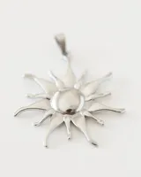 Dije de acero quirúrgico con forma de sol.