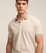Polo de manga corta color beige, confeccionada en algodón con cuello jacquard y ribete en las mangas.