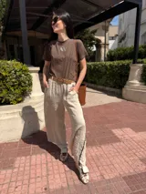 Pantalón de lino color beige, de corte amplio, con bordados en los laterales y bolsillos.