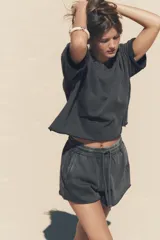 Shorts de tiro alto confeccionados en tejido con efecto lavado, cintura elástica ajustable con cordones, bolsillos laterales de vivo y tejido combinado en rib a tono.