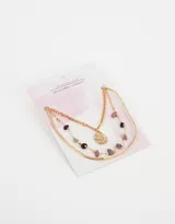 Collar corto dorado de tres hilos con dije de sol y piedras naturales de color lila y negro.