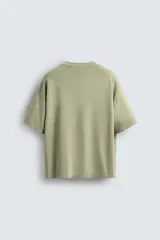 Camiseta verde oliva de corte holgado, cuello redondo y manga corta.