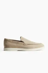 Mocasines color beige de gamuza con costura tradicional y suela blanca de goma.