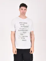 Remera gris melange con estampado de texto en el frente.