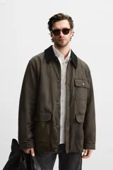 Parka relaxed fit color verde oscuro confeccionada en tejido de algodón con acabado encerado. Tiene cuello solapa combinado en pana negra, manga larga acabada en puño ajustable con botón a presión, bolsillos frontales de plastrón con solapa, bolsillo interior y cierre frontal de botonadura oculta por solapa.