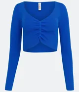 Blusa cropped azul de punto acanalado con escote en V, mangas largas y fruncido frontal.