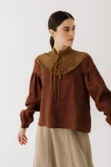 Blusa color marrón de lino con cuello alto de crochet y lazos.
