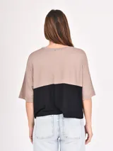 Remera manga corta con diseño color block, parte superior color beige y parte inferior color negro.