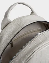 Mochila negra con efecto piel de cocodrilo, bolsillo frontal con cierre, charm de monedero colgante, correas regulables, manija superior, doble cierre superior y bolsillos laterales.
